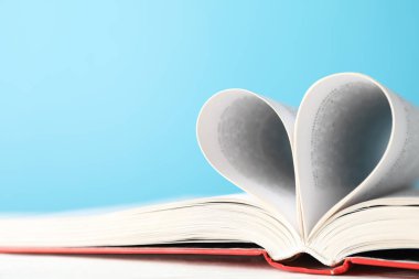 Sayfalardan yapılmış bir kalp. Mavi arkaplana karşı kitap, tex için boşluk