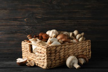 Ahşap arka planda sepetteki farklı mantarlar.