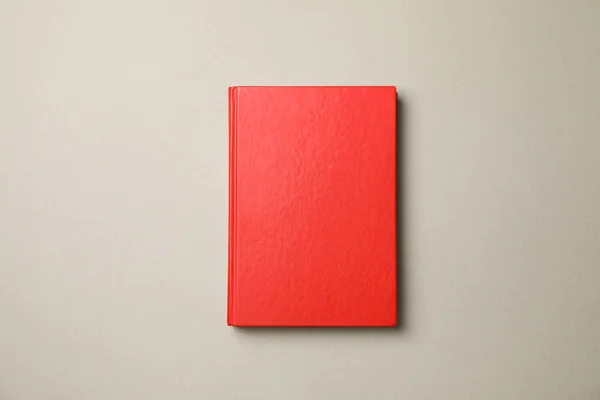 Červená kniha na šedém pozadí, horní pohled a kopírovat prostor — Stock fotografie