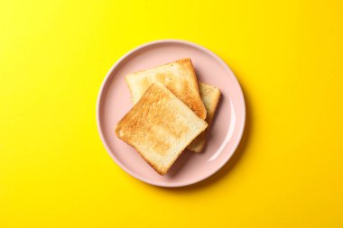 Sarı arka planda lezzetli tost tabağı, üst manzara.