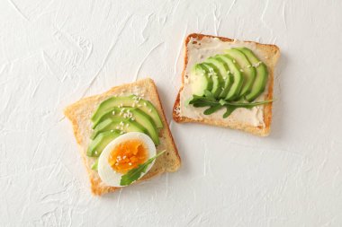 Beyaz arka planda avokado ve yumurta ile tost, üst görünüm