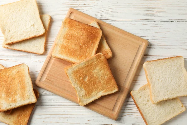 Panneau avec toasts sur fond blanc en bois, vue de dessus — Photo