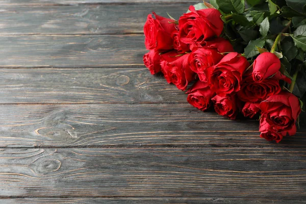 Strauß rote Rosen auf hölzernem Hintergrund, Platz für Text — Stockfoto