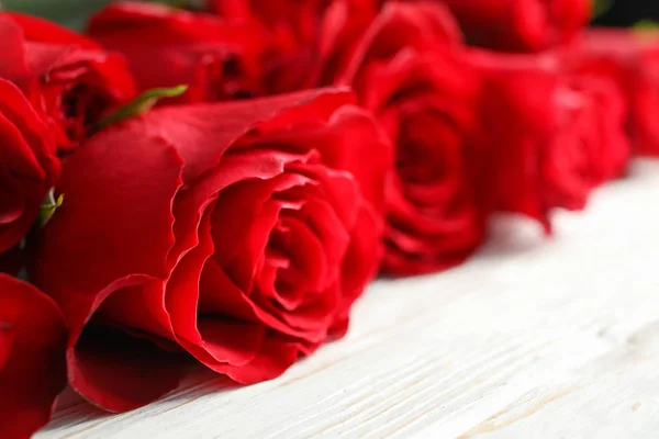 Schöne Rosen auf weißem Holz rustikalem Hintergrund, Nahaufnahme — Stockfoto