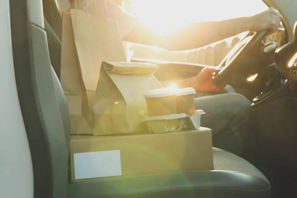 Boş kutu, kahve fincanları, kağıt paketler ve arabada kurye. Teslimat — Stok fotoğraf