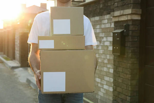 Leverancier houdt blanco dozen buiten, ruimte voor tekst — Stockfoto