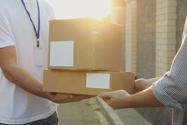 Man ontvangt dozen van bezorger buiten, lege ruimte — Stockfoto