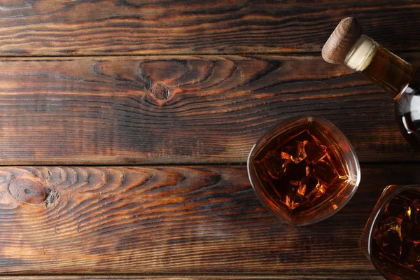 Botella y vasos de whisky sobre fondo de madera, vista superior —  Fotos de Stock