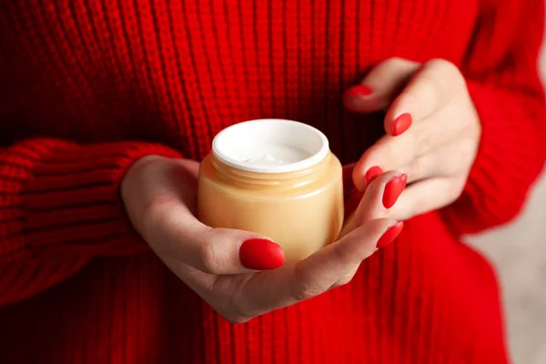 Mujer sosteniendo tarro de crema hidratante, primer plano. Cosmeti de invierno — Foto de Stock