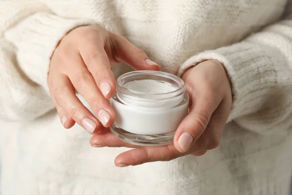 Woman holding jar of moisturizing cream, closeup. Winter cosmeti — Stock Photo, Image