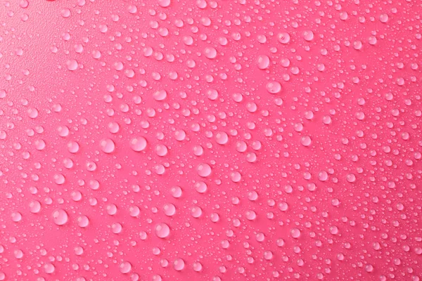 Muitas gotas de água no fundo rosa. Textura de fundo . — Fotografia de Stock