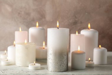 Kahverengi arka planda farklı yanan mumlar, kapat