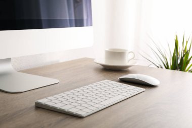 Bilgisayarlı işyeri, tabağı ahşap masada olan fincan ve pla