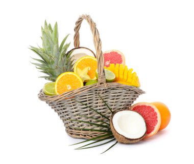 Beyaz arka planda izole edilmiş egzotik meyveli hasır sepet.