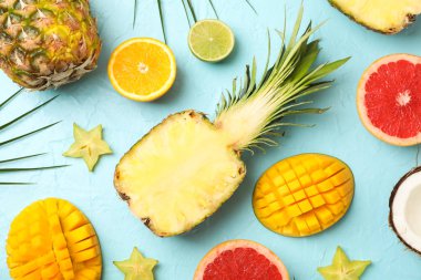 Mavi arka planda egzotik meyveler içeren kompozisyon, üst görünüm