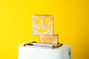 Tost makinesi ve tost makinesi, sarı arka planda gülen surat, boşluk...