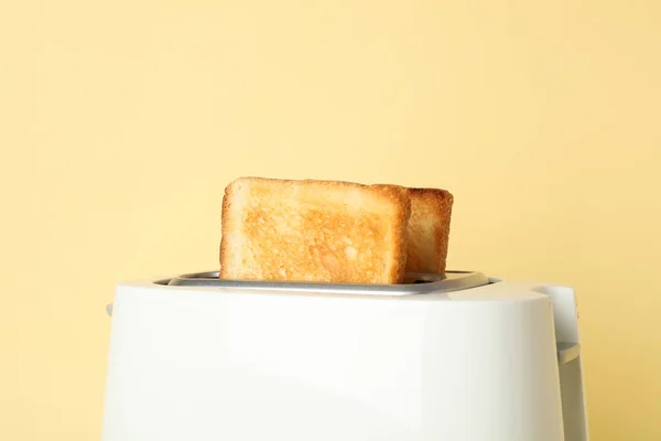 Toaster mit Brotscheiben auf beigem Hintergrund, Nahaufnahme — Stockfoto