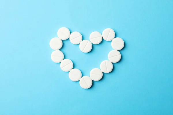 Corazón hecho de píldoras sobre fondo azul, espacio para texto — Foto de Stock