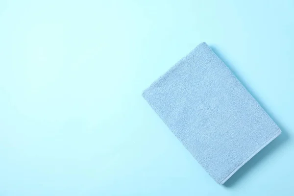 Toalha de cor dobrada no fundo azul, espaço para texto — Fotografia de Stock