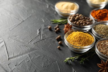Siyah arka planda farklı baharat ve malzeme içeren kaseler.,