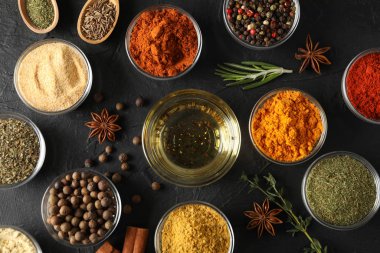 Siyah arka planda farklı baharat ve malzeme içeren kaseler.,