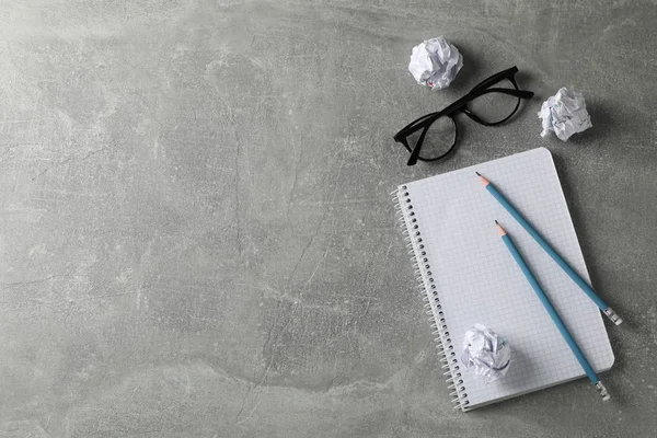 Papper bollar, anteckningsbok, glasögon och pennor på grått bord, topp vi — Stockfoto