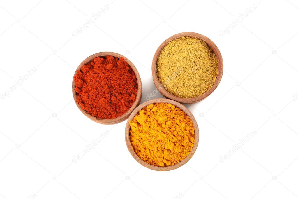 Wooden bowls with red pepper, curry and turmeric powder isolated