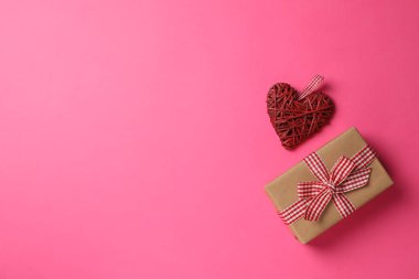 Pembe arka planda hediye kutusu ve dekoratif kalp, metin için boşluk