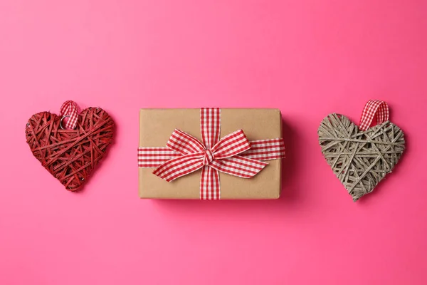Caixa de presente e corações decorativos em fundo rosa, espaço para tex — Fotografia de Stock