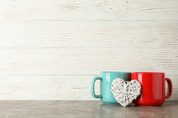 Dos copas y corazón decorativo sobre mesa gris, espacio para texto —  Fotos de Stock