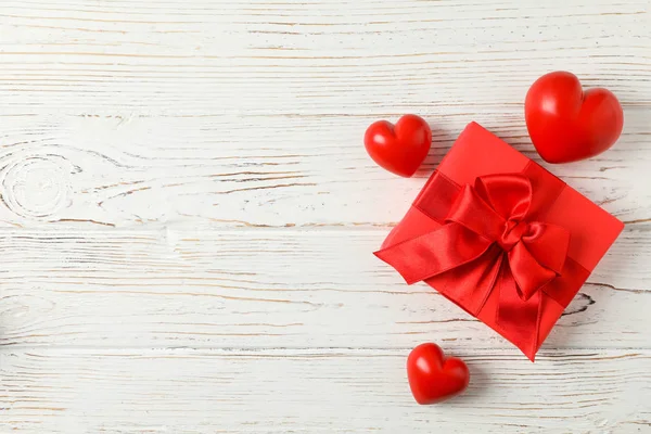 Caja de regalo con arco y corazones sobre fondo de madera, espacio para tex — Foto de Stock
