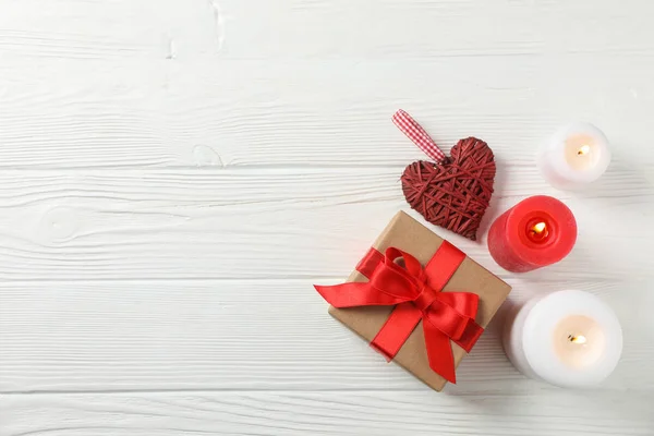 Caja de regalo, velas y corazón sobre fondo de madera blanco, espacio fo — Foto de Stock