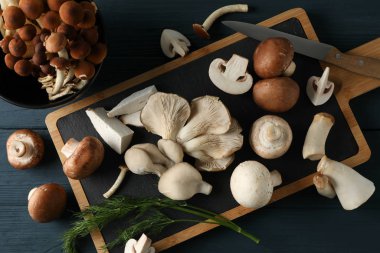 Farklı mantarlar, dereotu, kase ve tahta masa, üst v