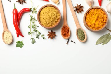 Farklı baharat ve malzemelerle bembeyaz kaşıklar ve kaseler 