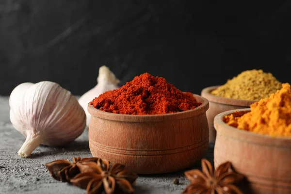 Schalen met kruiden en ingrediënten op grijze achtergrond, close-up — Stockfoto