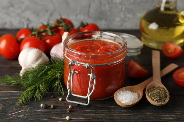 Chilli sauce, garlic, cherry tomatoes, olive oil, spices on wood — Stock Photo, Image