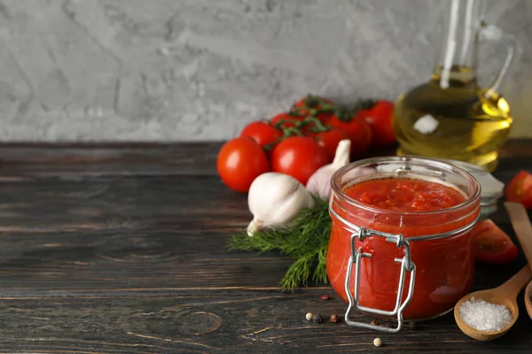 Chilli sauce, garlic, cherry tomatoes, olive oil, spices on wood — Stock Photo, Image