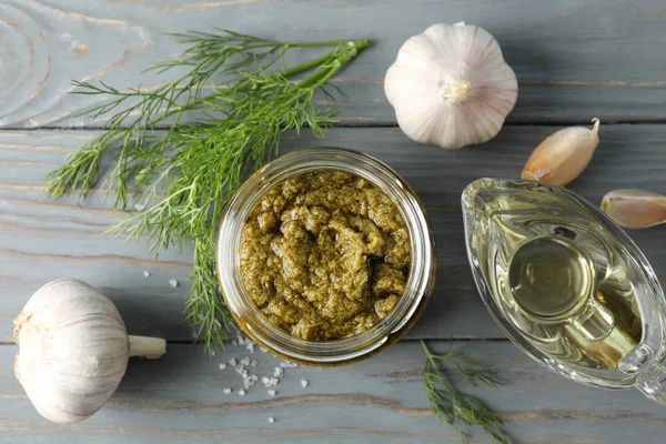 Mísa pesto omáčka, česnek, olivový olej, sůl na šedém pozadí, — Stock fotografie