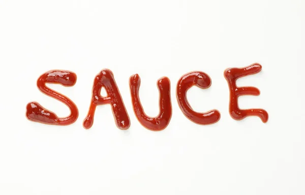 Inscripción SAUCE hecha de salsa sobre fondo blanco, vista superior — Foto de Stock