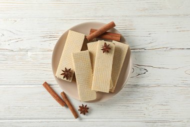 Beyaz ahşap arka planda gofret ve tarçın tabağı, üst v