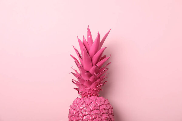 Раскрашенный розовый ананас на цветном фоне, пространство для текста
