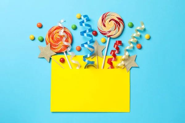 Gelber Umschlag mit Geburtstagszubehör auf blauem Hintergrund, sp — Stockfoto