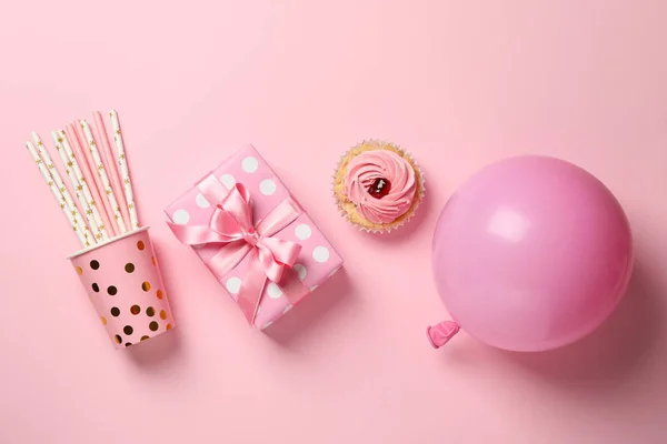 Geschenkbox, Luftballon, Cupcake und Pappbecher mit Strohhalmen auf rosa Bac — Stockfoto