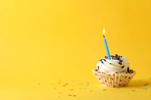 Cupcake with candle on yellow background, space for text — Stock Photo, Image