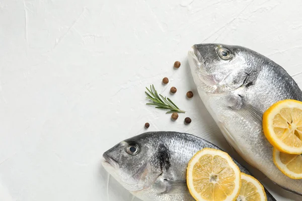 Fresh Dorado fishes, pepper, lemon and rosemary on white backgro — Stock Photo, Image