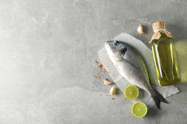 Dorado ryby, olej a koření na šedém pozadí, pohled shora — Stock fotografie