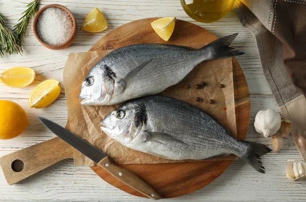 Deska s rybami Dorado a přísady do vaření na dřevěném hřbetě — Stock fotografie