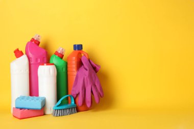 Deterjanlı şişeler ve sarı sırtüstü temizlik malzemeleri.