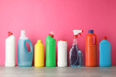 Pembe arka planda deterjanı olan şişeler, metin için boşluk