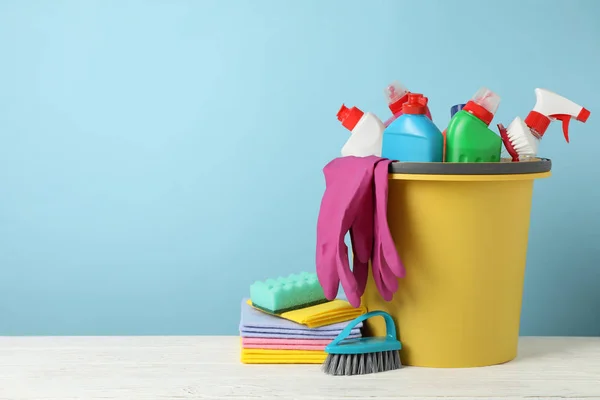 Cubo con detergente y artículos de limpieza sobre fondo azul , —  Fotos de Stock